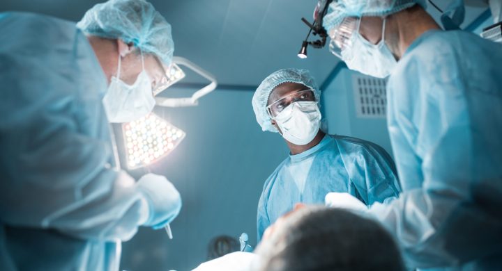 bottom view of multicultural surgeons operating patient in operating room