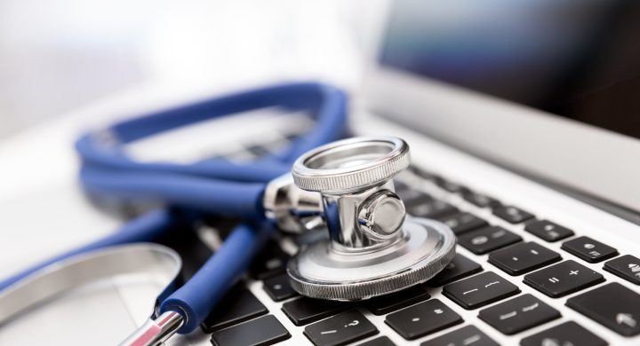 Stethoscope on laptop keyboard. Health care or IT security concept