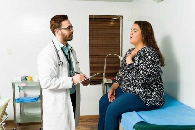 Stressed obese woman at the doctor's office talking about her health problems