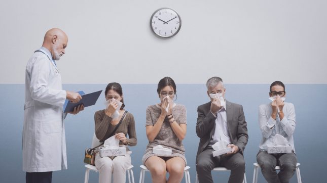 People with cold and flu at the hospital Sick people with cold and flu sitting in the waiting room at the hospital and blowing their noses, a doctor is checking medical records
